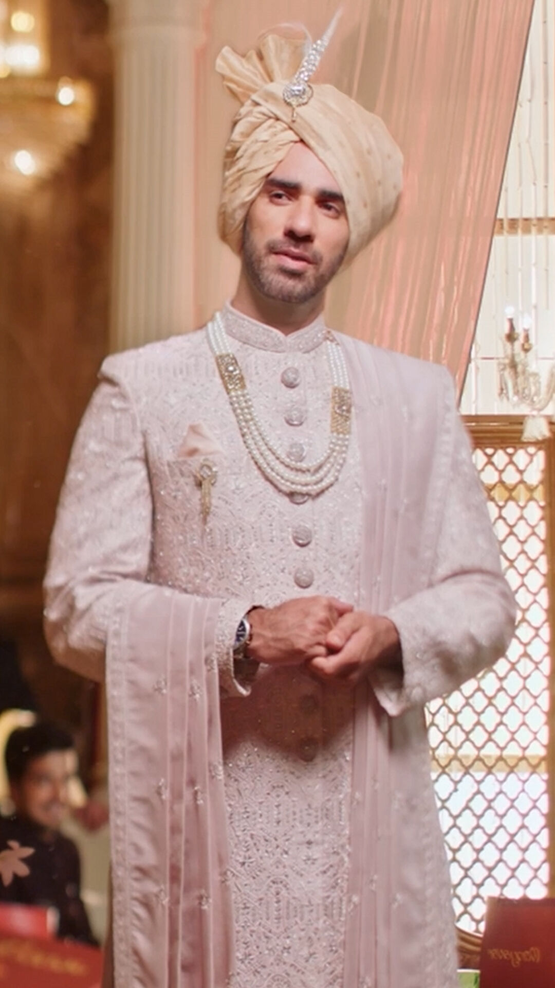 Refined shell white sherwani featuring a classic gold brooch, enhancing the groom's wedding look